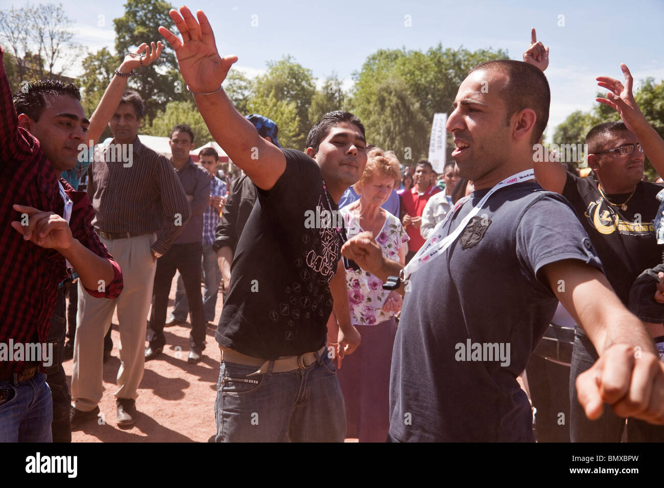 Junge asiatische Männer Bhangra Tanz auf ein überraschend staubigen Glasgow Mela 2010 in Kevingrove Park. Stockfoto