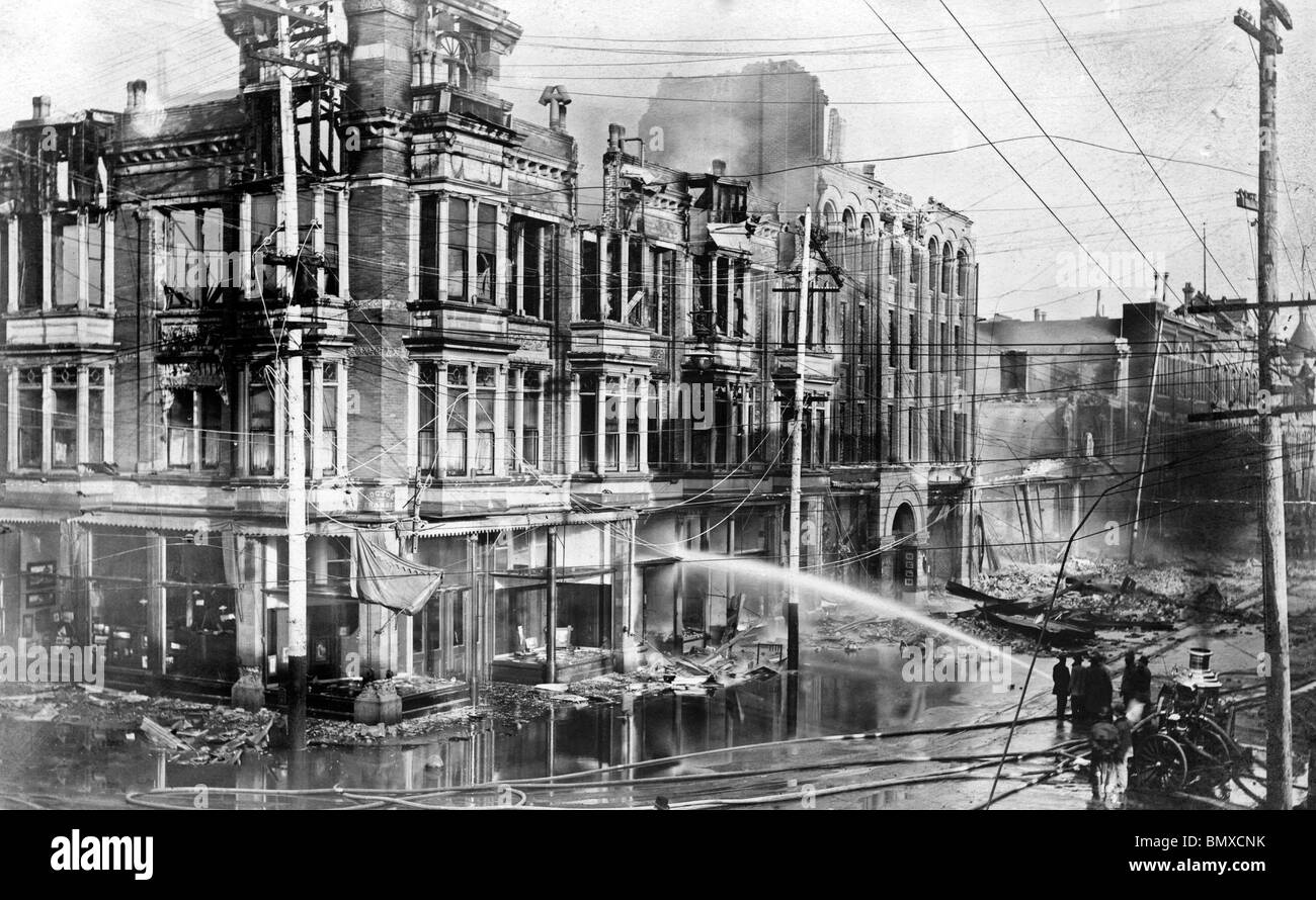 Block der verbrannten Gebäude in San Francisco nach dem Erdbeben 1906 mit Feuer LKW sprühen Wasser auf sie. Juni 1906 Stockfoto