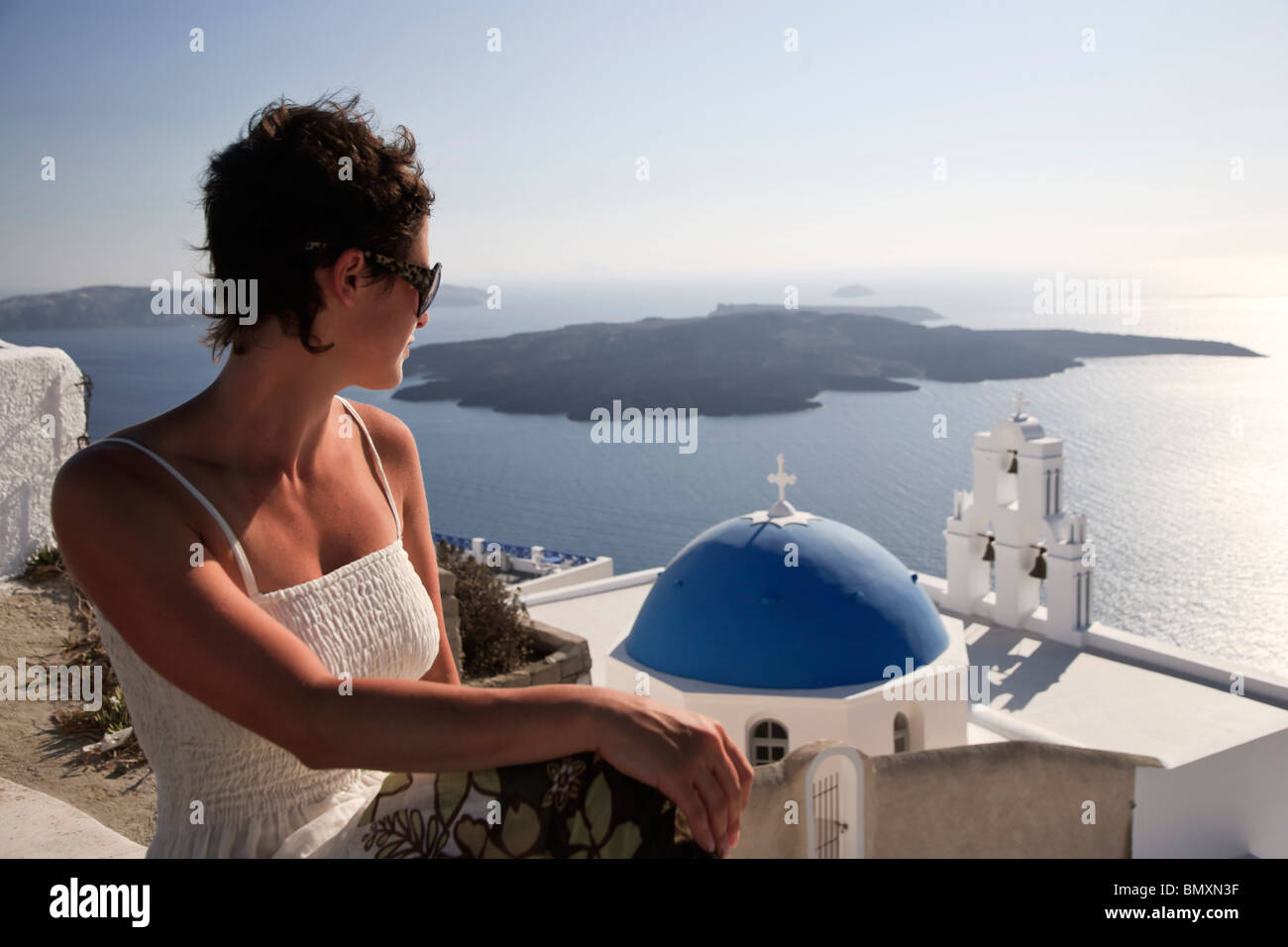 Cyclades, Santorini, Firostefani, Griechenland, junge Frau (25-30) auf der Suche auf Santorini Caldera (MR) Stockfoto