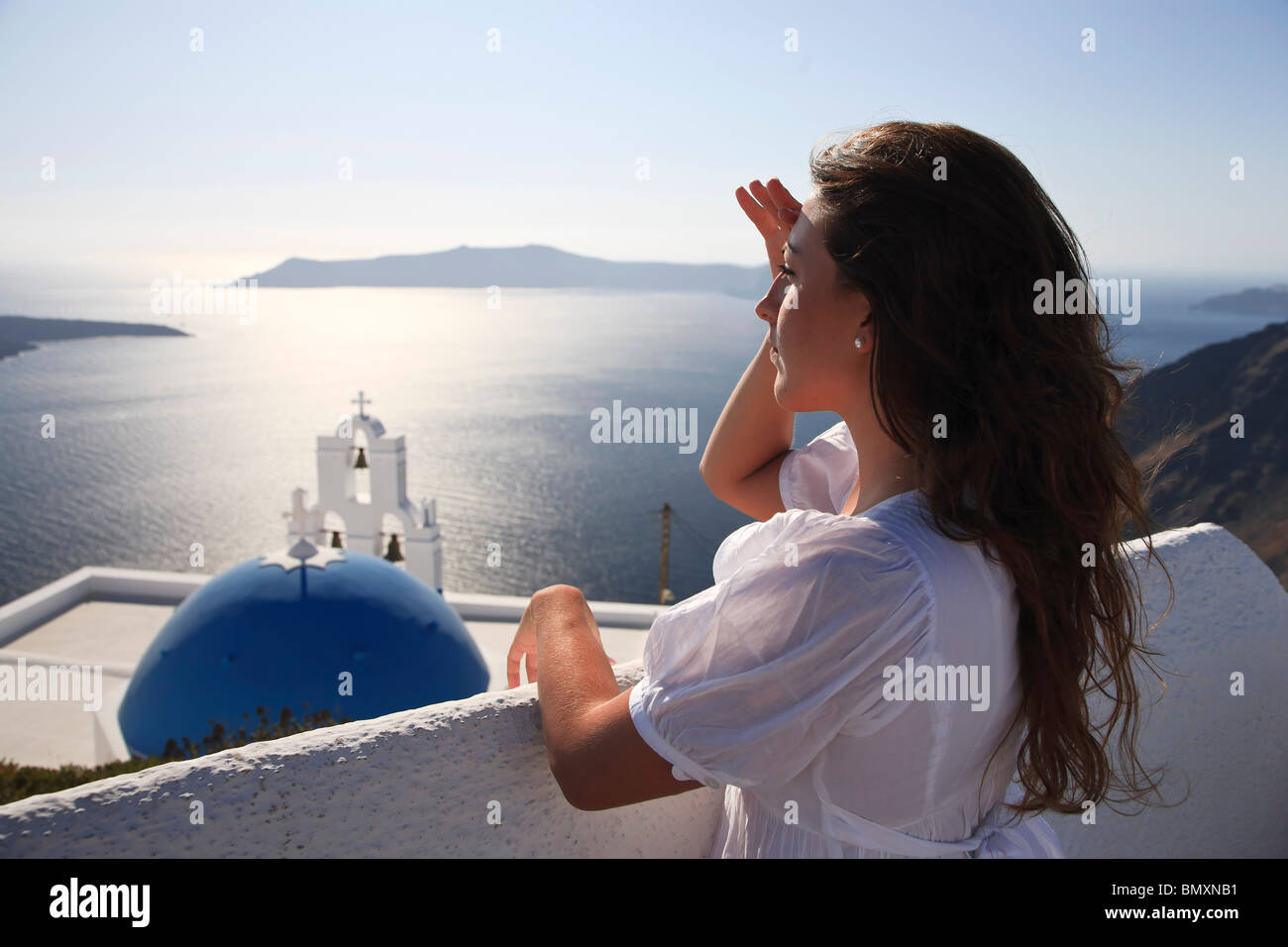 Cyclades, Santorini, Firostefani, Griechenland, junge Frau (25-30) auf der Suche auf Santorini Caldera (MR) Stockfoto