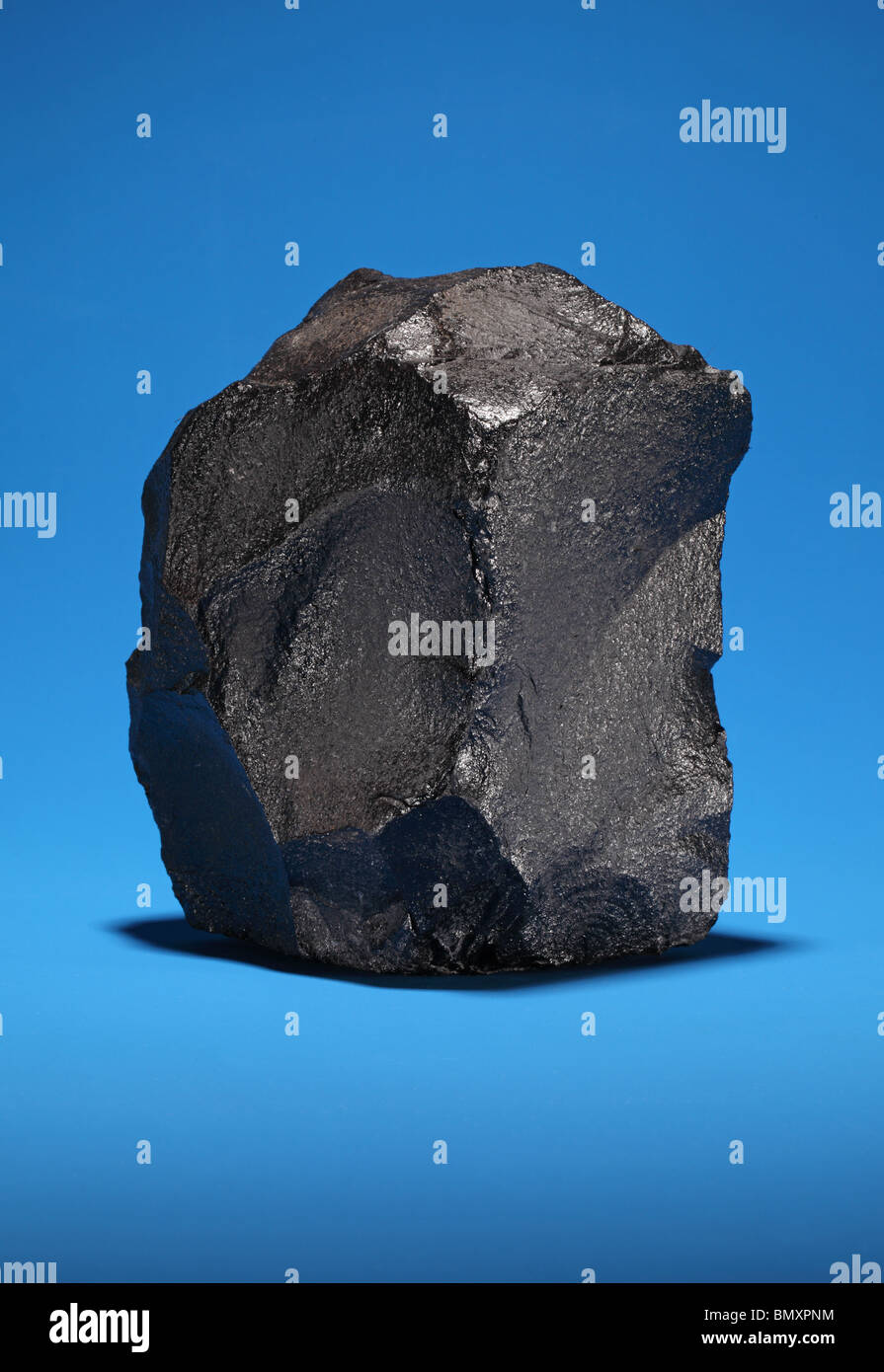 Ein großes Stück bituminöse Steinkohle auf einem leuchtend blauen Hintergrund Stockfoto