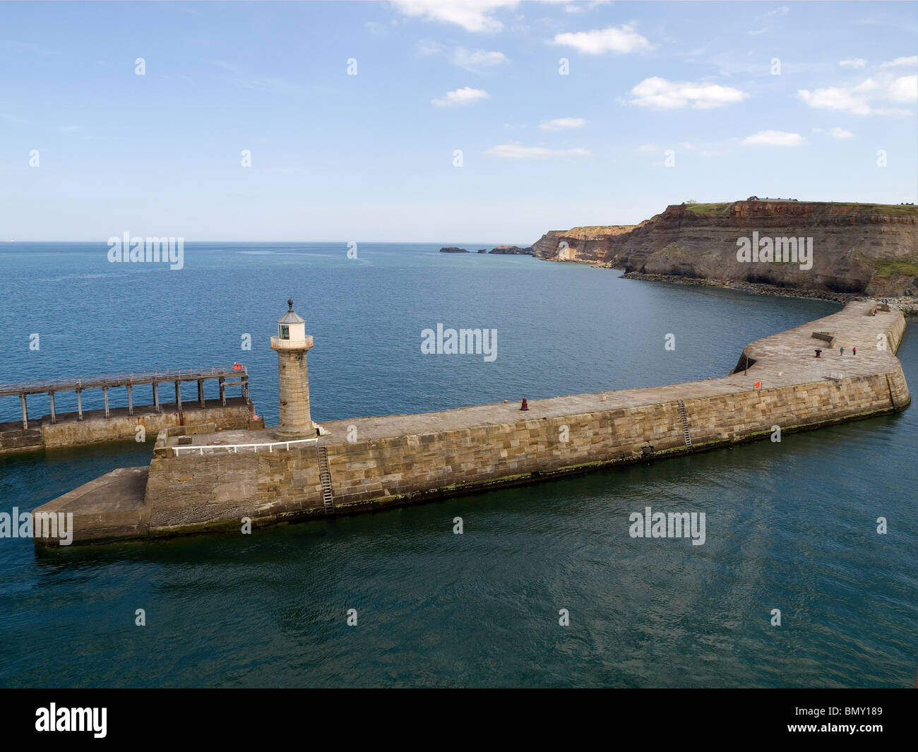 Whitby Hafen Ostwand und Leuchtturm mit Blick in Richtung gegen Bay West Leuchtturm entnommen Stockfoto