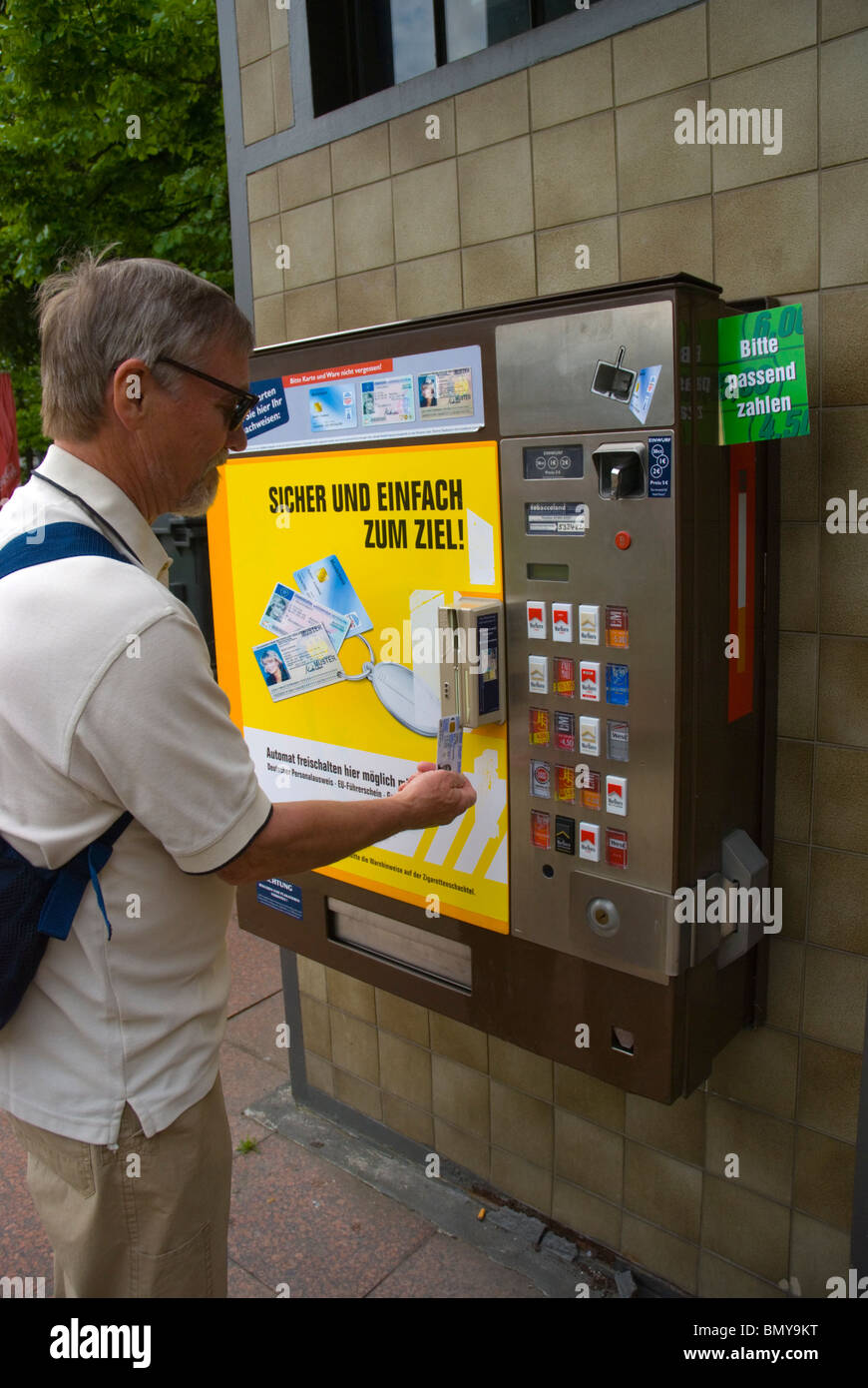 Mann mit seinem Personalausweis Zigaretten aus dem Automaten Berlin Deutschland Europa kaufen Stockfoto
