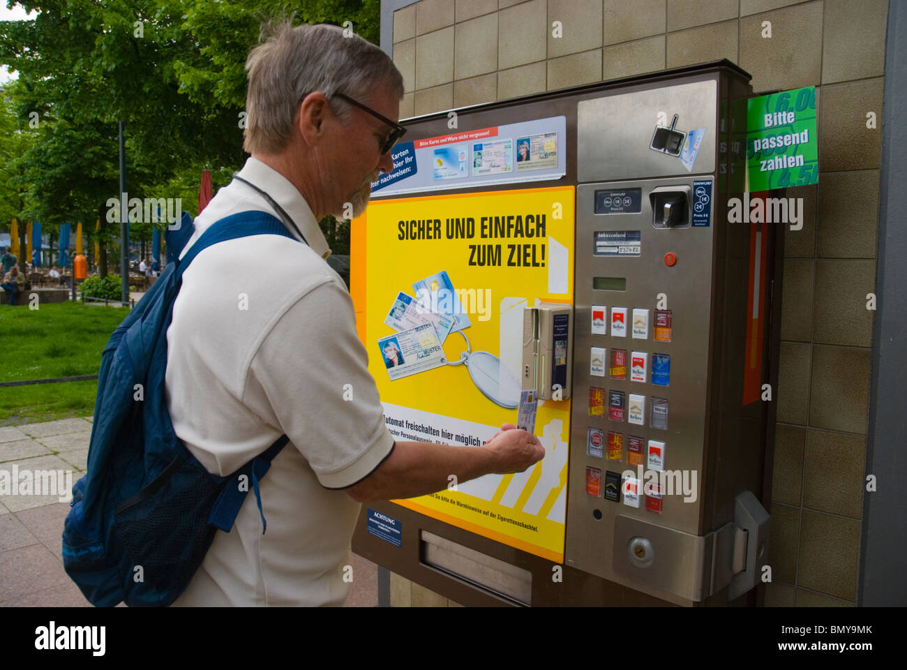 Mann mit seinem Personalausweis Zigaretten aus dem Automaten Berlin Deutschland Europa kaufen Stockfoto