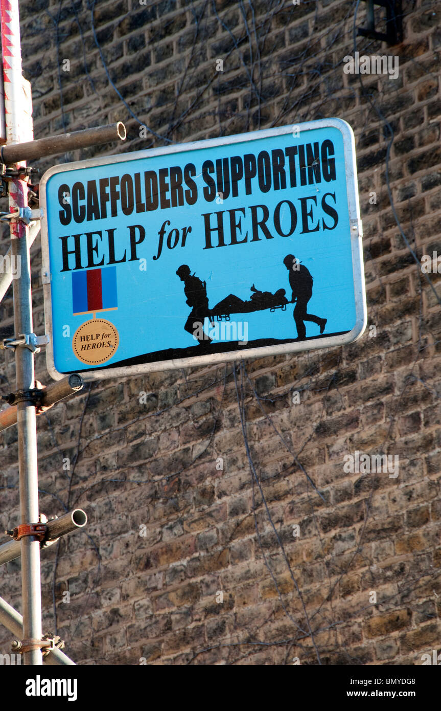 Gerüstbauer unterstützende Hilfe für Helden unterzeichnen auf einer Baustelle in Süd-London Stockfoto