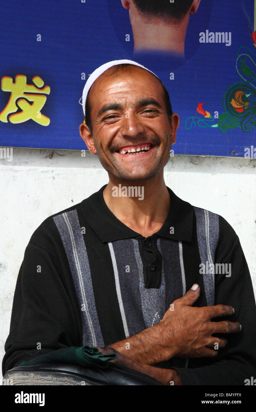 Ein glücklich aussehende am Straßenrand Händler bei strahlendem Sonnenschein in Kashgar, Westprovinz Xinjiang, China. Stockfoto