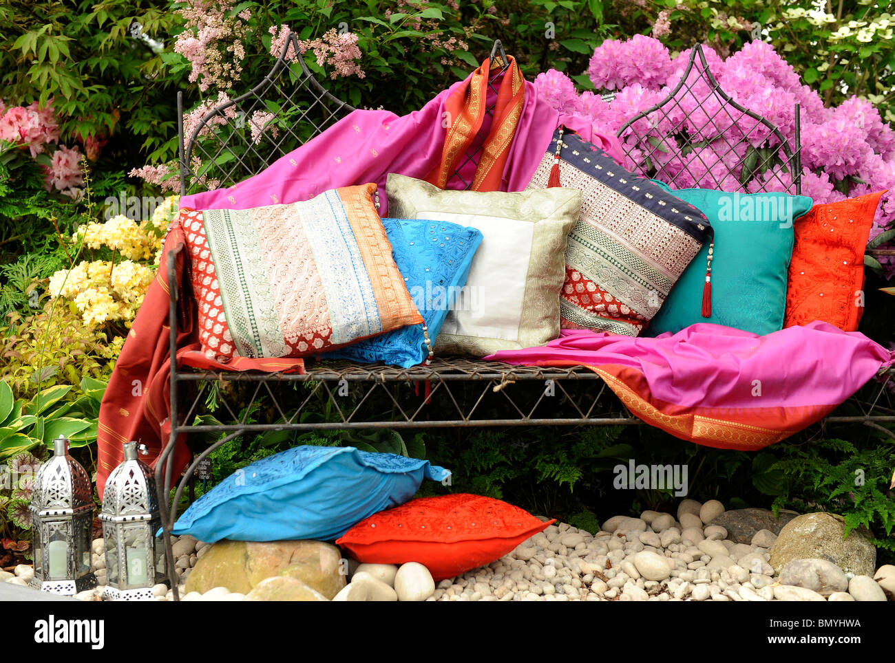 Bunte Kissen auf eine Gartenbank Stockfoto