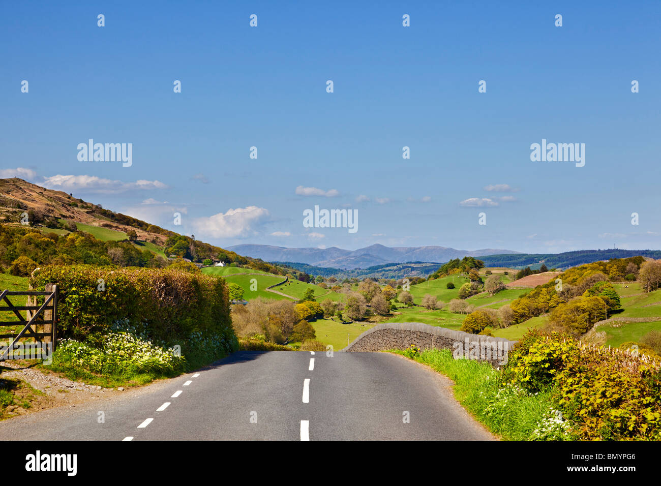 Land straße, durch die englische Landschaft auf dem Weg zur Lake District Bergen auf einen Road Trip in Cumbria, England, Großbritannien Stockfoto