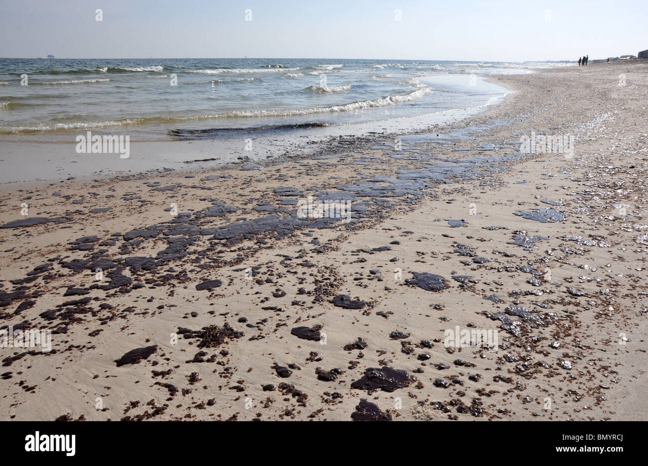 Ölpest am Strand mit off Shore Bohrinsel im Hintergrund. Stockfoto
