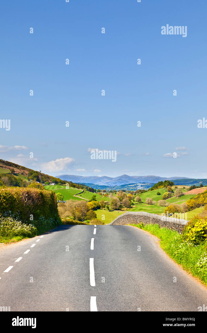 Offene Straße durch die malerische englische Landschaft in Richtung der Lake District Berge auf einem Roadtrip in Cumbria England Großbritannien Stockfoto