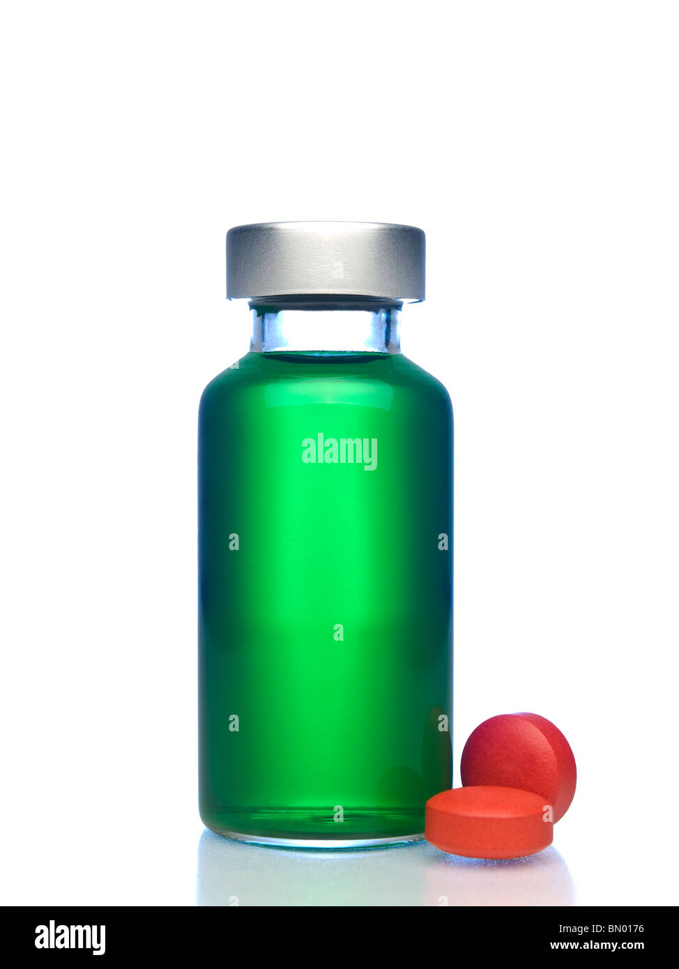 Isolierte Fläschchen voll von grünen Flüssigkeit, rote Pillen beiseite. Stockfoto