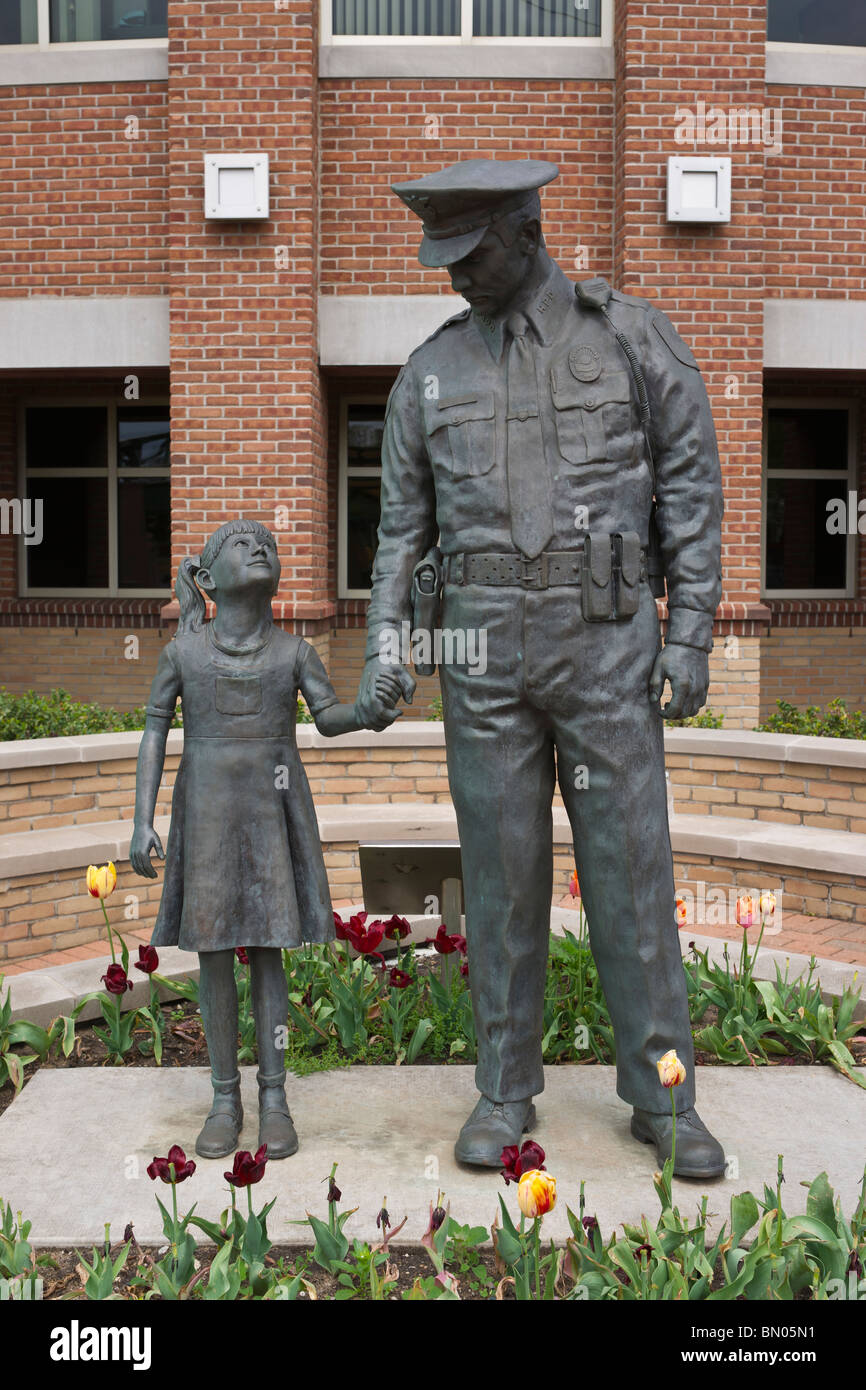 Tulip Time Festival Dutch Holland Michigan in den USA die Skulpturengruppe Protector Stone zeigt einen Polizisten, der ein kleines Mädchen mit hochauflösenden Händen hält Stockfoto