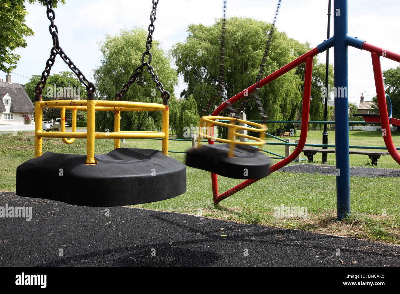 Leere Schaukel auf ein Kind Spielplatz, Bewegung auf einer Schaukel Stockfoto