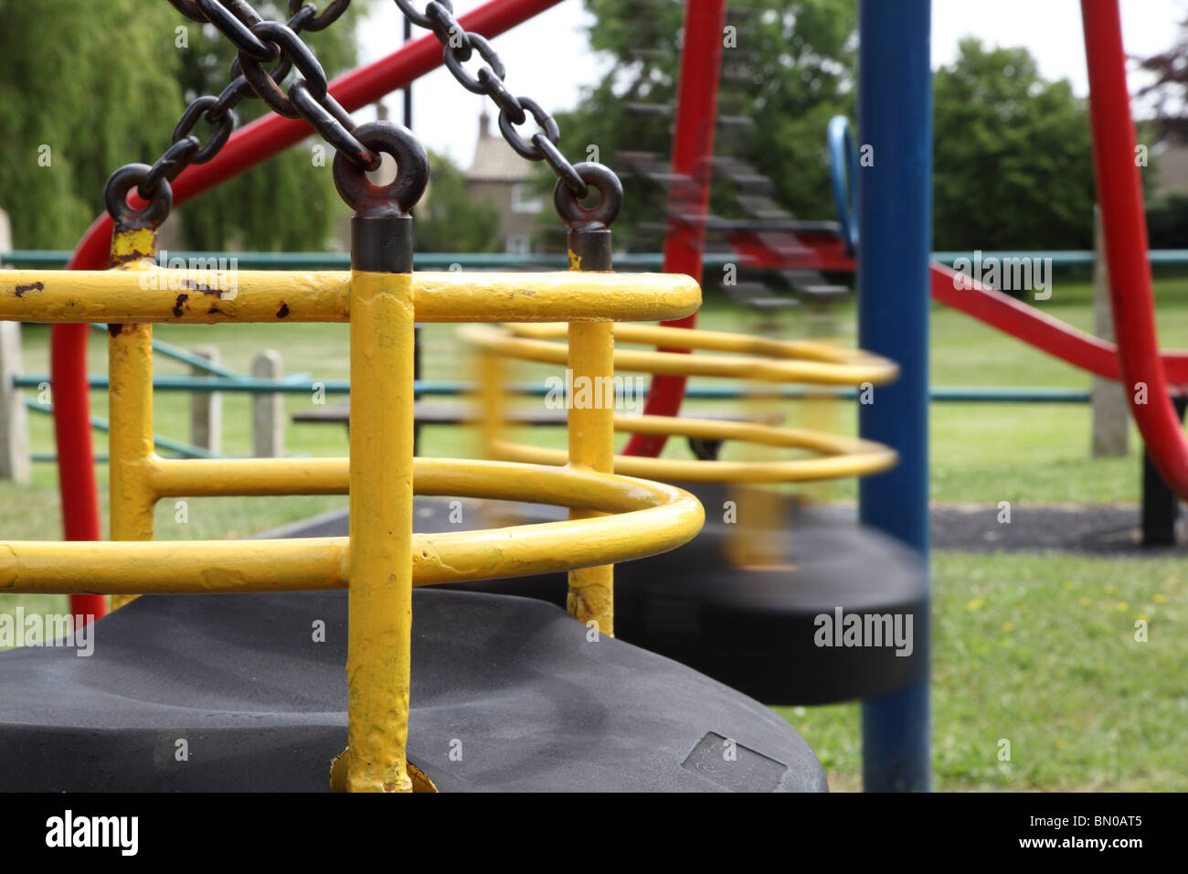 Leere Schaukel auf ein Kind Spielplatz, Bewegung auf einer Schaukel Stockfoto