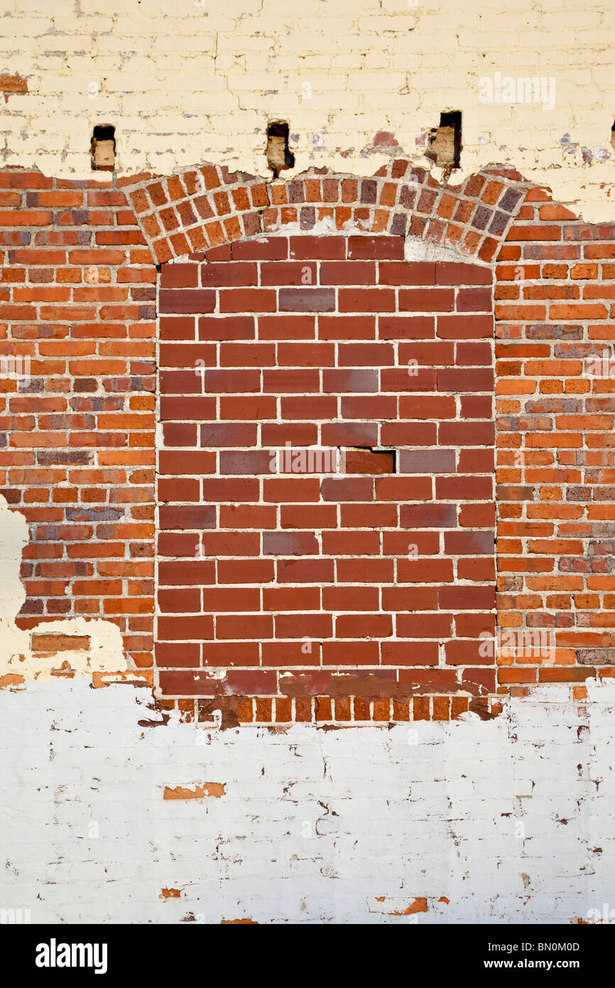 Ocala, FL - Mär 2009 - alte Ziegel Wand mit Alter Farbe und Rundbogenfenster ausgefüllt Stockfoto