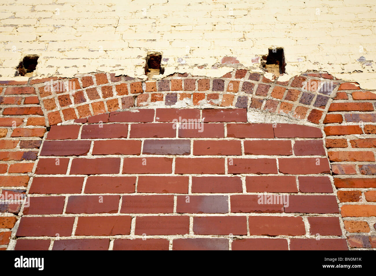 Ocala, FL - Mär 2009 - alte Ziegel Wand mit Alter Farbe und Rundbogenfenster ausgefüllt Stockfoto