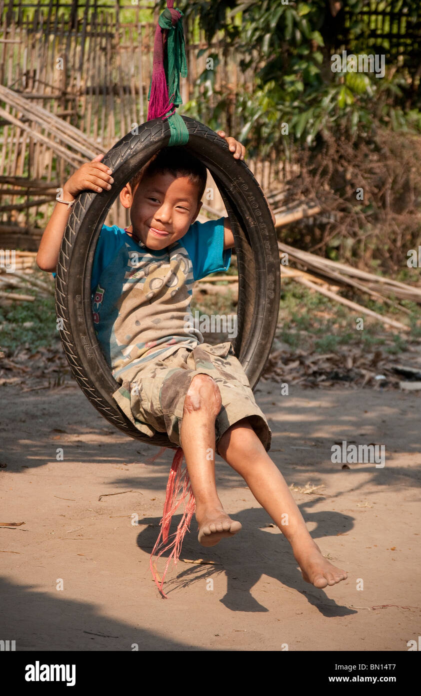 Kleiner Junge spielte in Reifenschaukel im Baan Tong Luang, Dorf der Hmong Leute im ländlichen Provinz Chiang Mai, Thailand. Stockfoto
