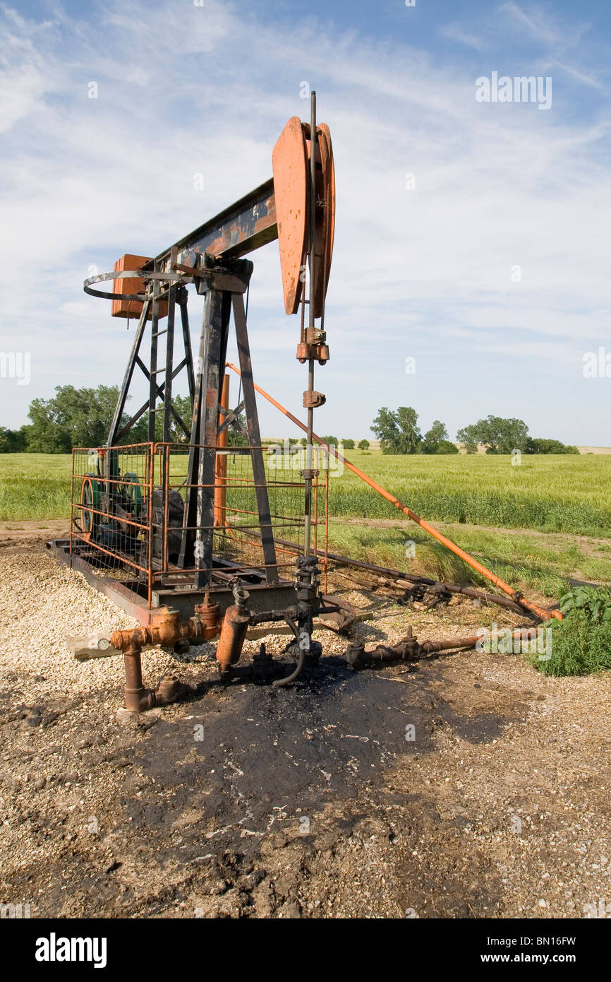 Orange und schwarz rostig Ölquelle Pumpe in einem Feld Stockfoto