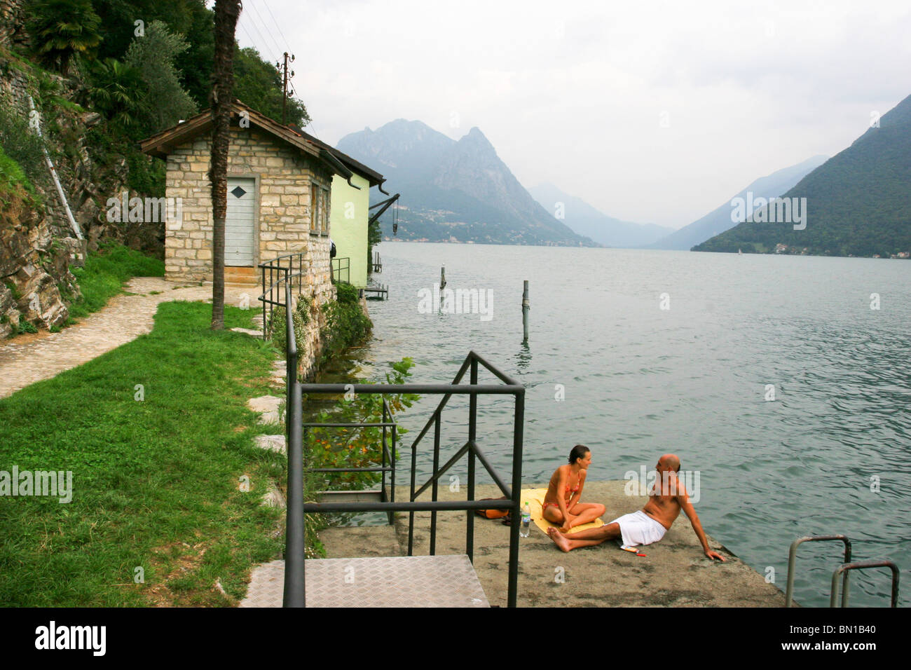 Schweiz, Lago di Lugano, ein paar sitzt in ihren Badeanzügen in der Nähe von Luganersee in Gandria, Stockfoto