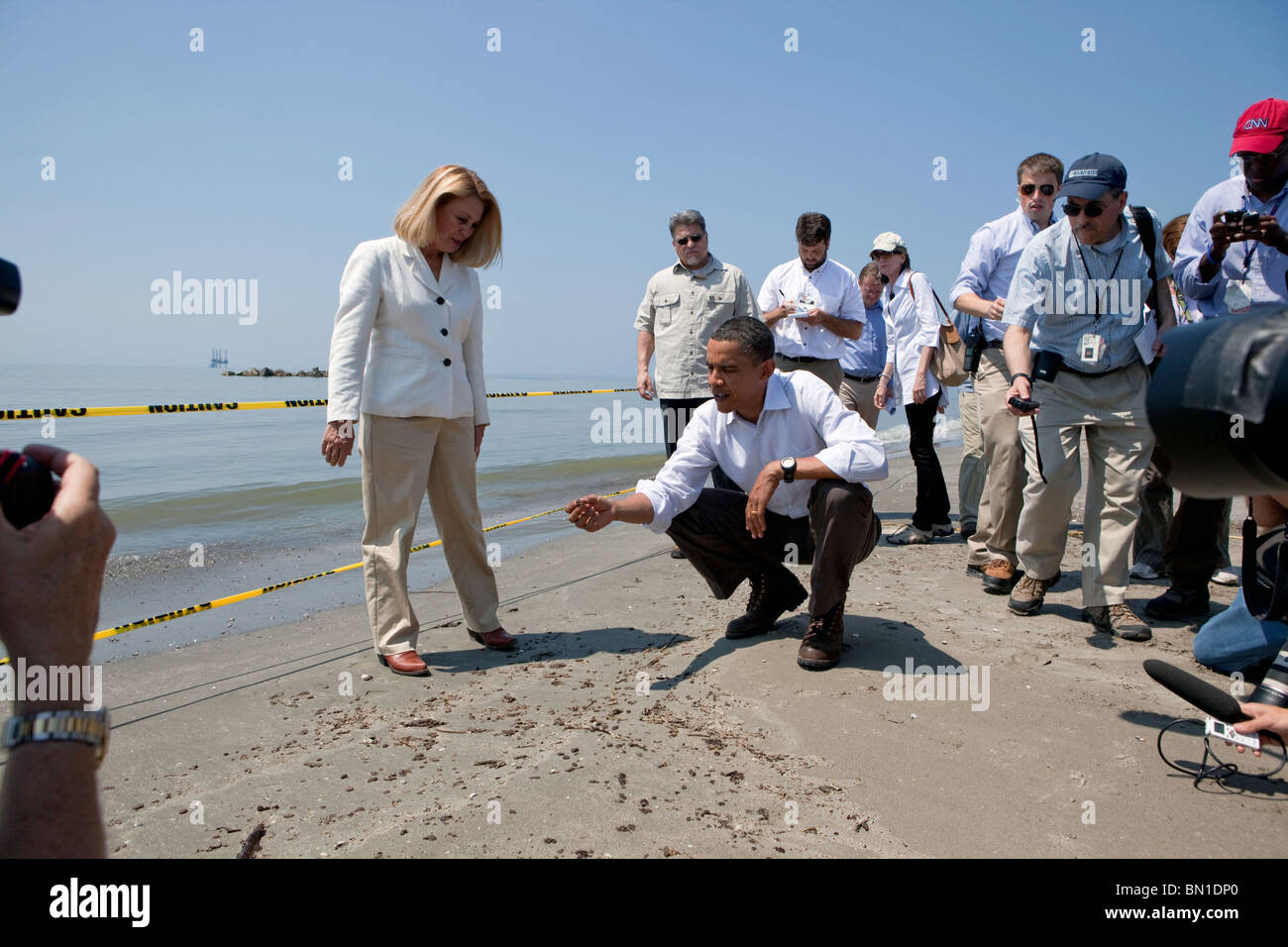 Barack Obama und Lafourche Parish President Charlotte Randolf, links, inspizieren einen Tar-Ball während der BP-Ölpest Stockfoto