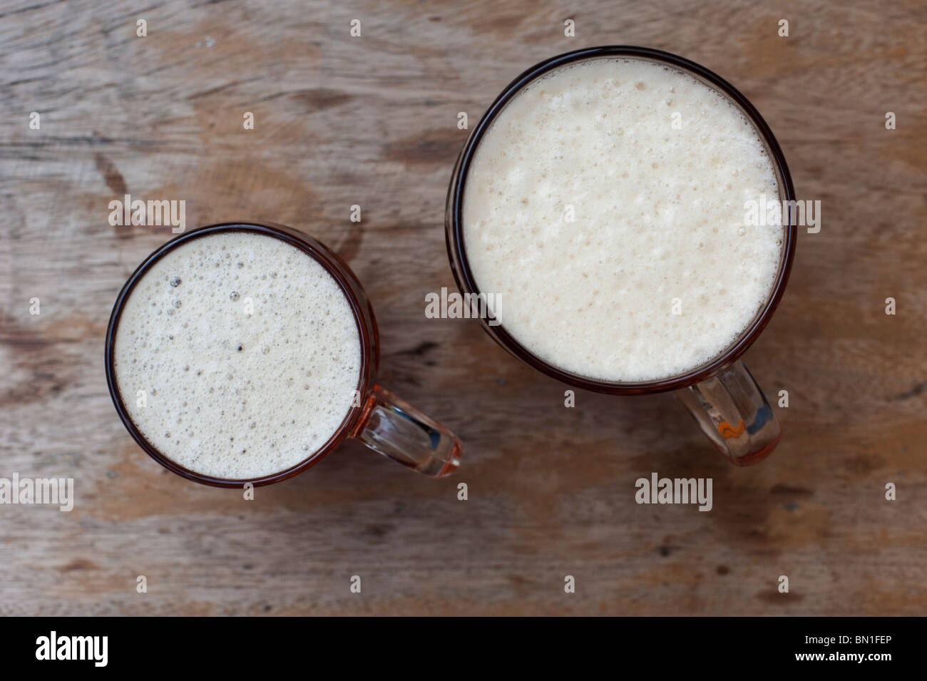Ein Winzling und eine volle Pint "Alte Hooky" Bier auf einem verwitterten Gartentisch in einem Pub. Stockfoto