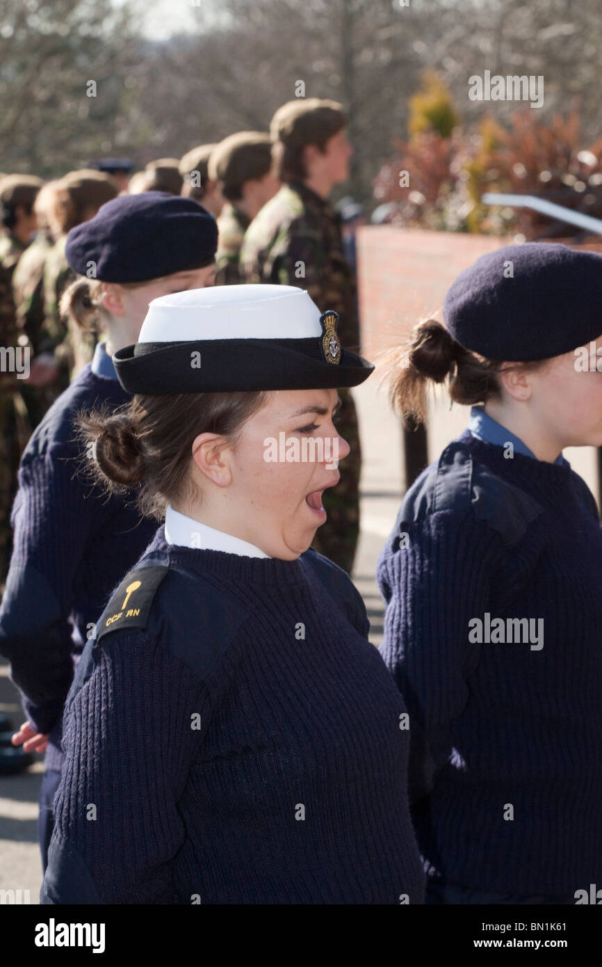 Junge Frau Marineoffizier gähnt auf eine kombinierte Officer Cadet Corps Inspektion Stockfoto