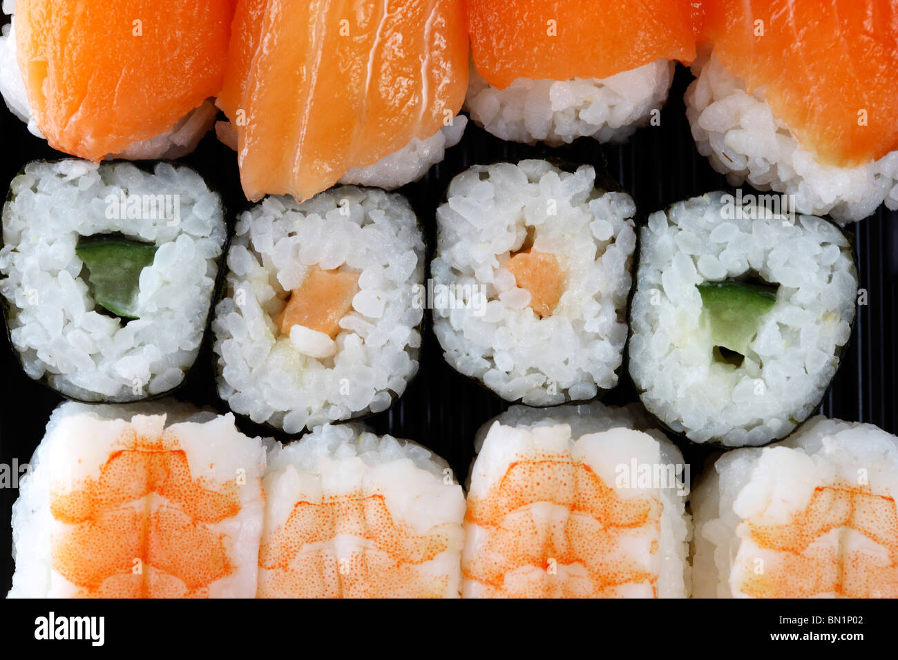 Verschiedene Sushi und Sashimi Stück in einer Box zum mitnehmen, in einem Supermarkt. Stockfoto
