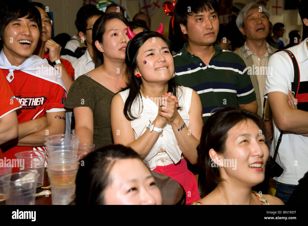 Ein aufgeregt weibliche südkoreanische Fußballfans beobachten ihre Mannschaft spielen Uruguay in einem Londoner Pub während der WM 2010 Stockfoto