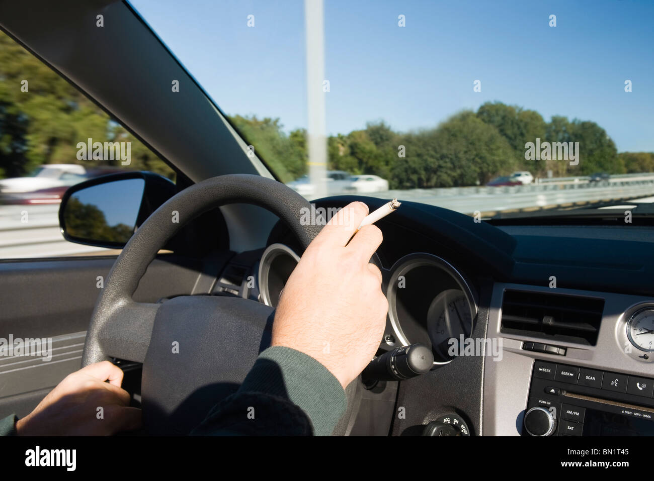 Rauchen einer Zigarette während der Fahrt Stockfoto