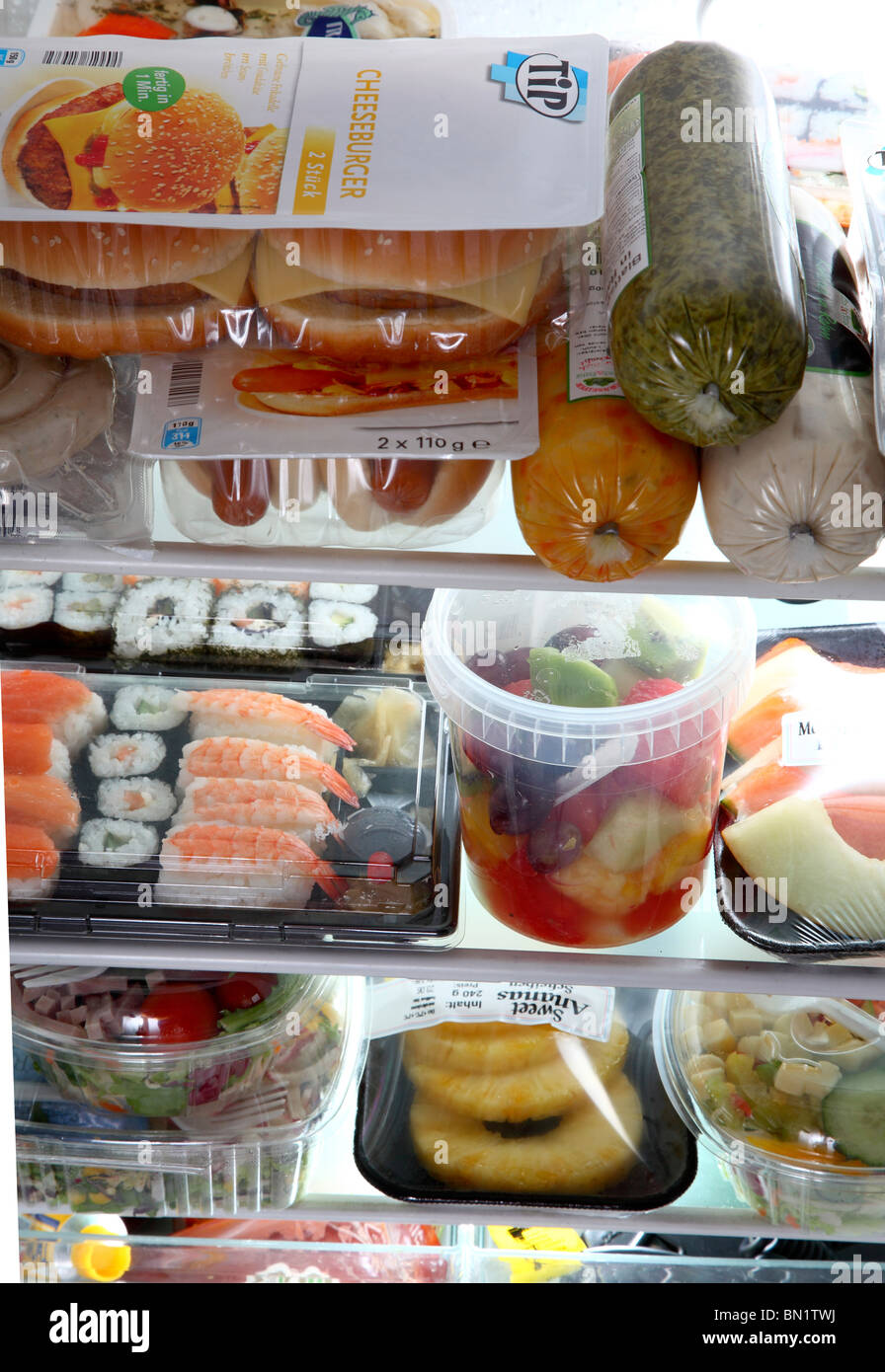 Kühlschrank gefüllt mit verschiedenen Convenience-Food-Produkten. Alle Ready-to-eat Mahlzeiten. Salat, Fleisch, Speisen, Sushi, Gemüse. Stockfoto