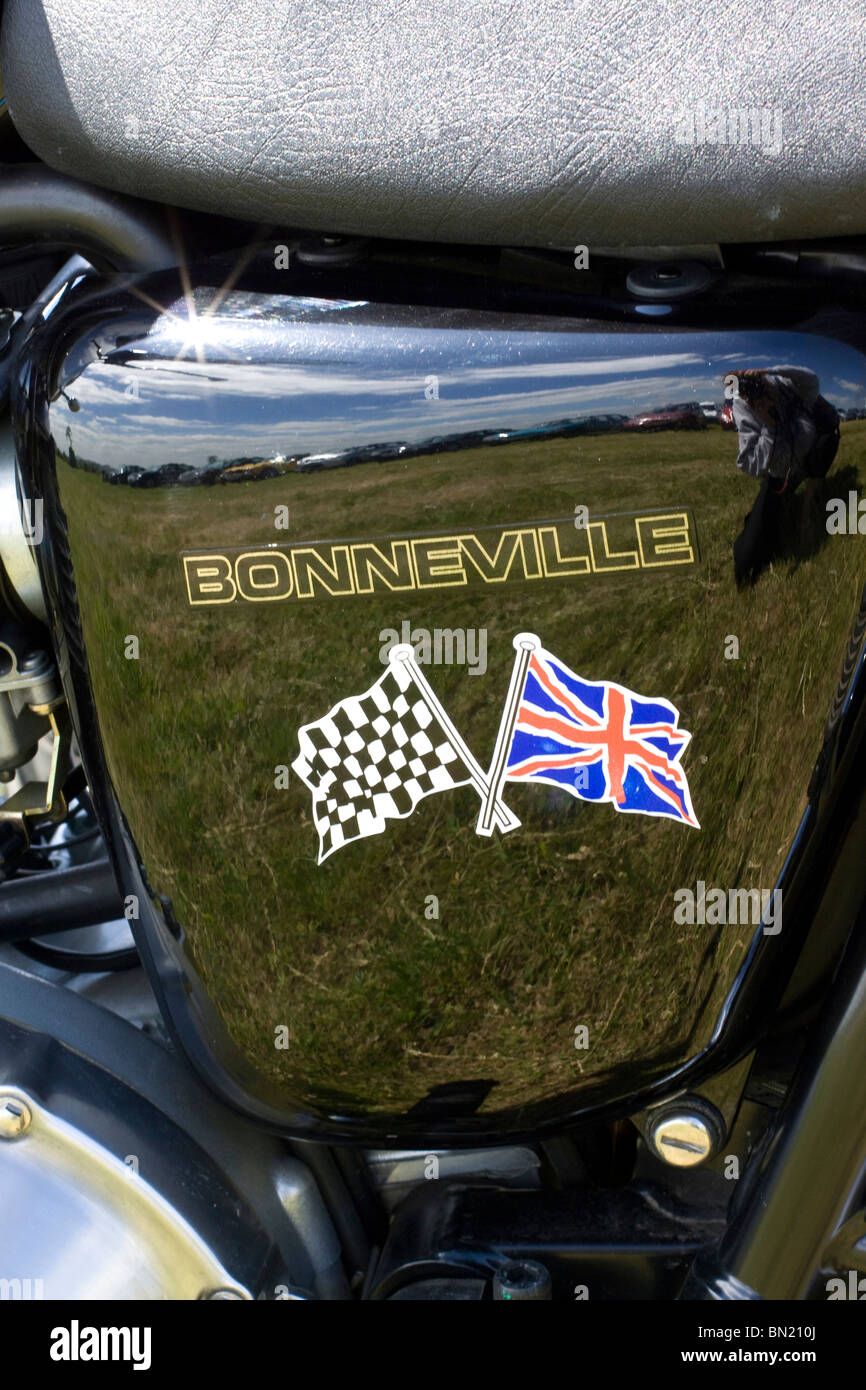 Eine Gedenktafel auf einem Motorrad Triumph Bonneville mit der britischen Flagge und Zielflagge Stockfoto