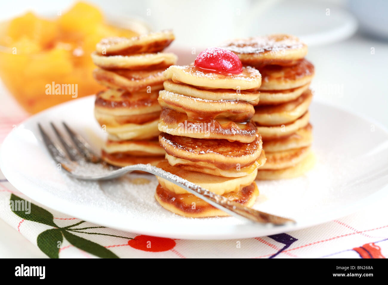 Süße Pfannkuchen mit Kompott und Pancake Maker-Hintergrund Stockfoto