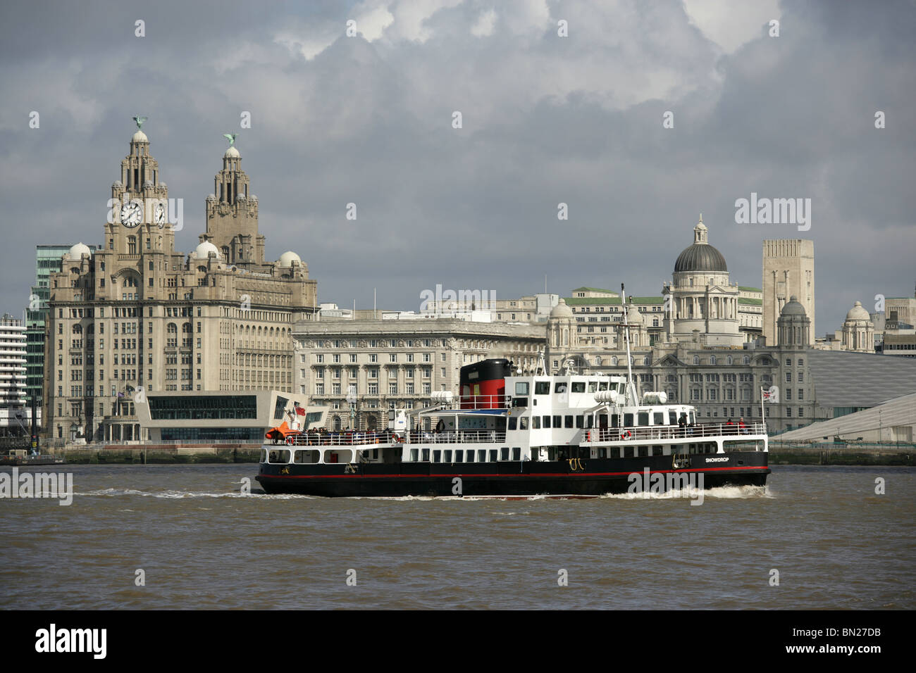 Stadt von Liverpool, England. Die drei Grazien an Liverpools Pier Head Waterfront mit der Mersey Ferry im Vordergrund. Stockfoto