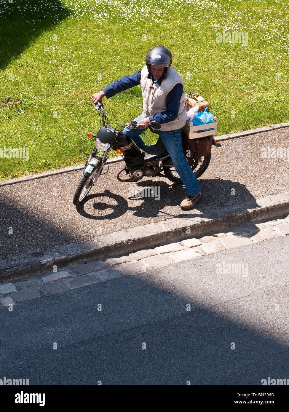 Mann ab Moped abgestellt auf Bürgersteig (Moped Fahrer ohne Lizenz nach Alkohol am Steuer Überzeugungen verwendet) - Frankreich. Stockfoto