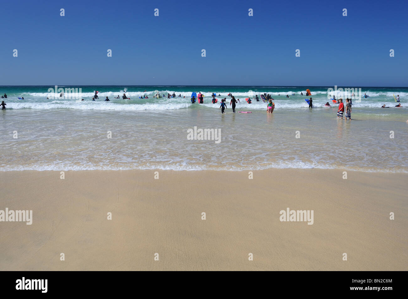Schwimmer und Surfer genießen Sie einen sonnigen Tag und ein klares Meer Stockfoto