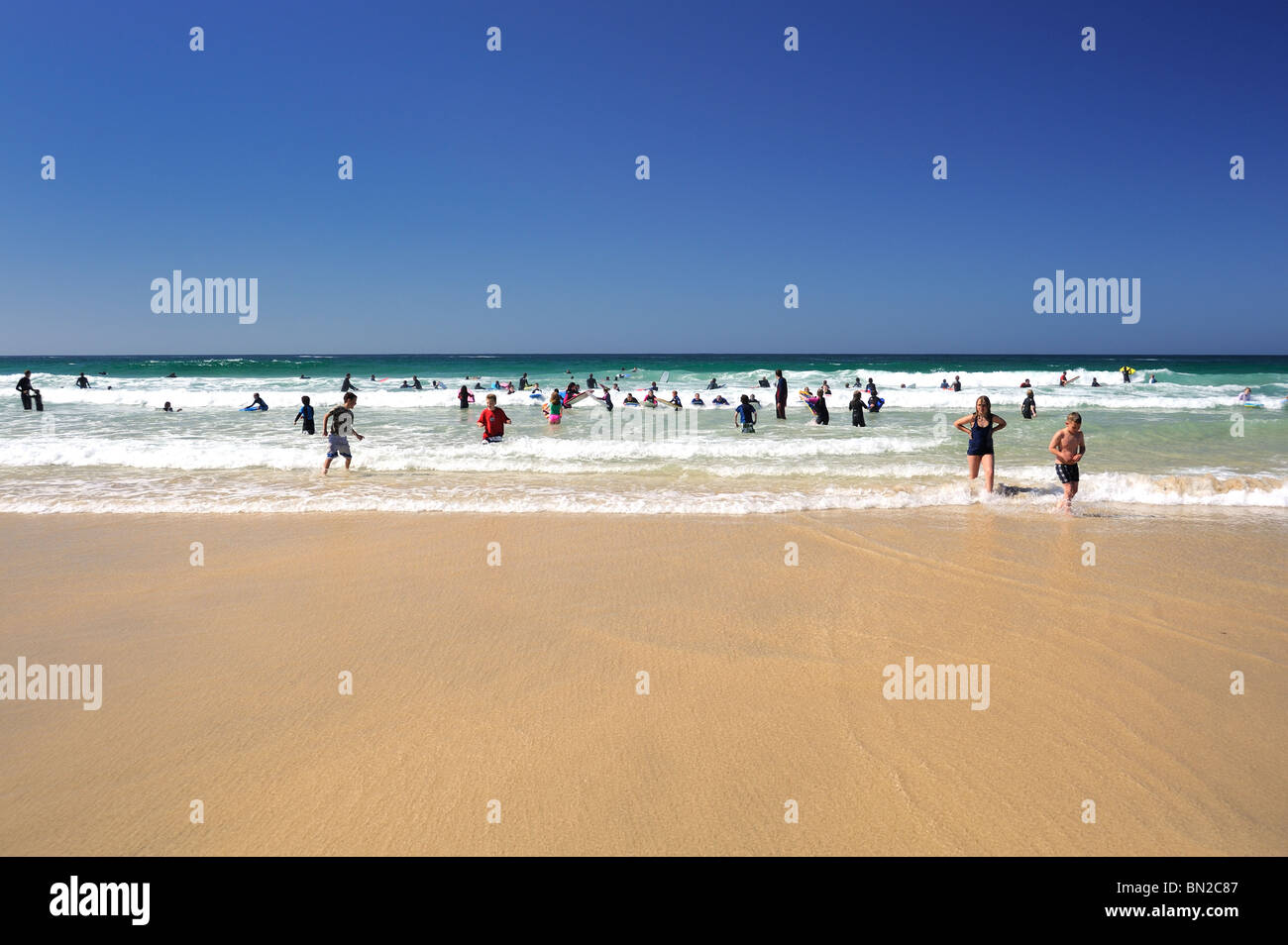 Schwimmer und Surfer genießen Sie einen sonnigen Tag und ein klares Meer Stockfoto