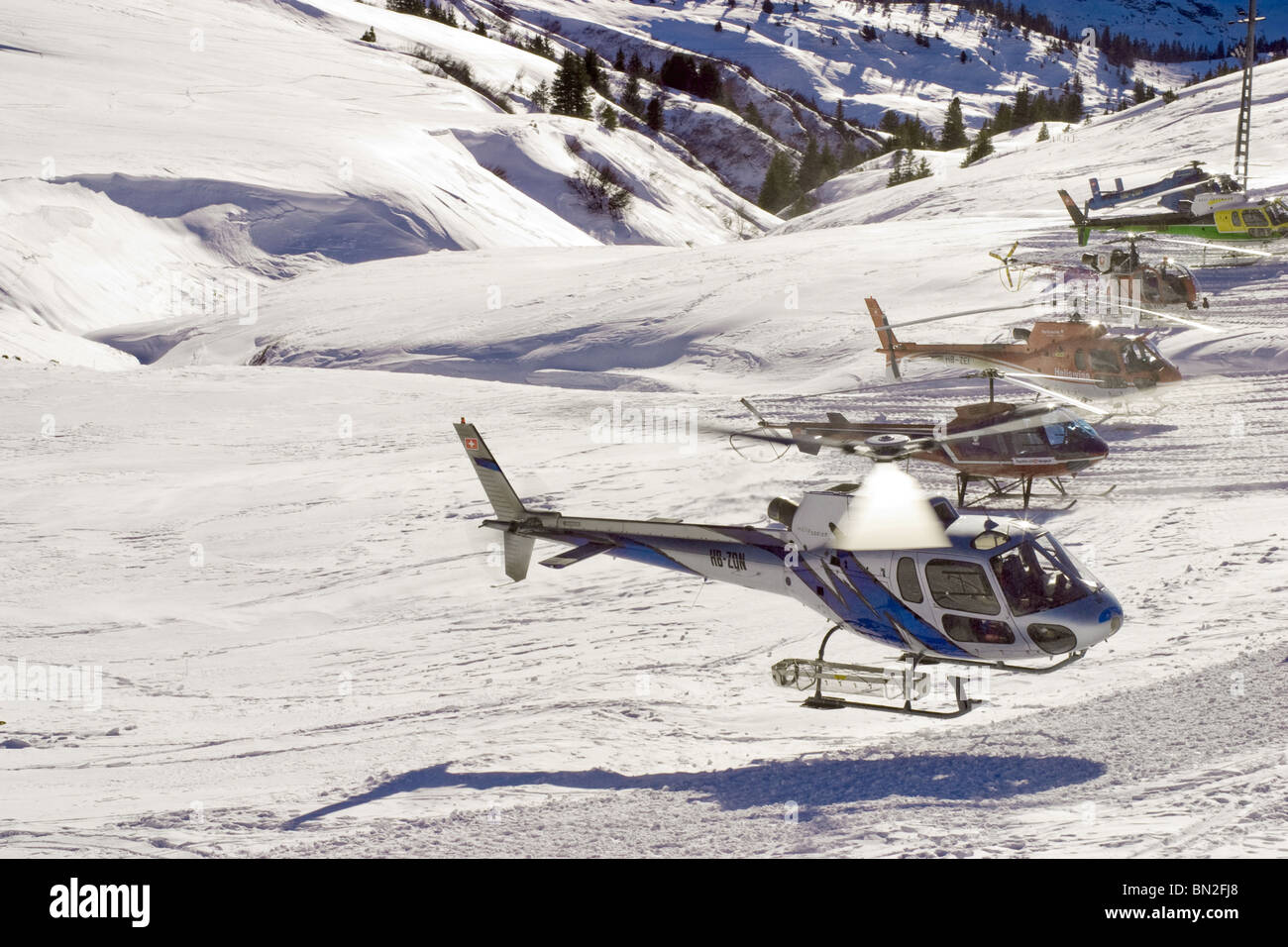 Schweizer Alpen Ski Resort Jungfrauregion: Chopper in Schweizer Bergen warten auf Passagiere, Rennen Skifahrer während Skispiele Stockfoto