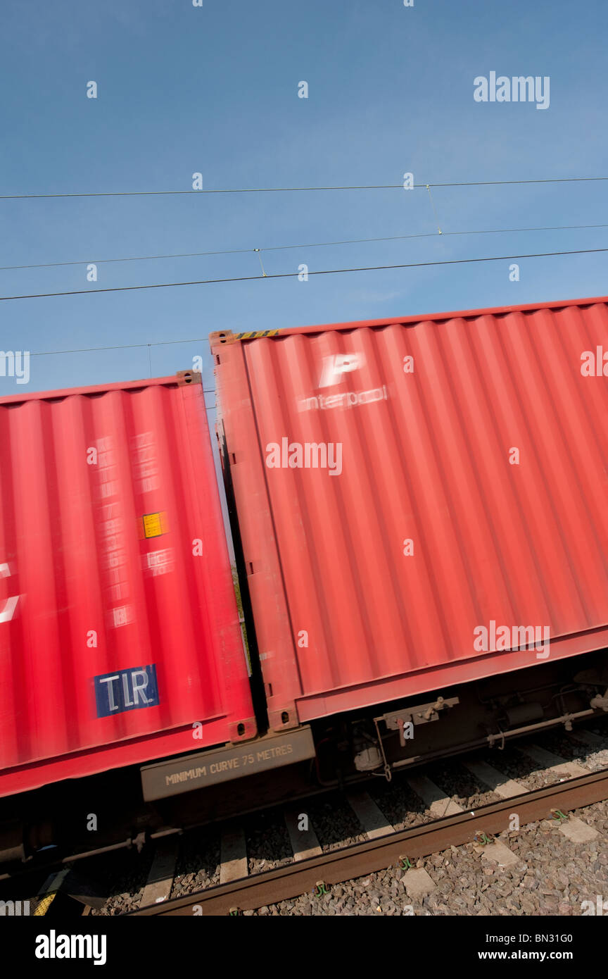 Fracht-Container am Zug entlang der englischen Eisenbahn vorbei zu beschleunigen. Stockfoto