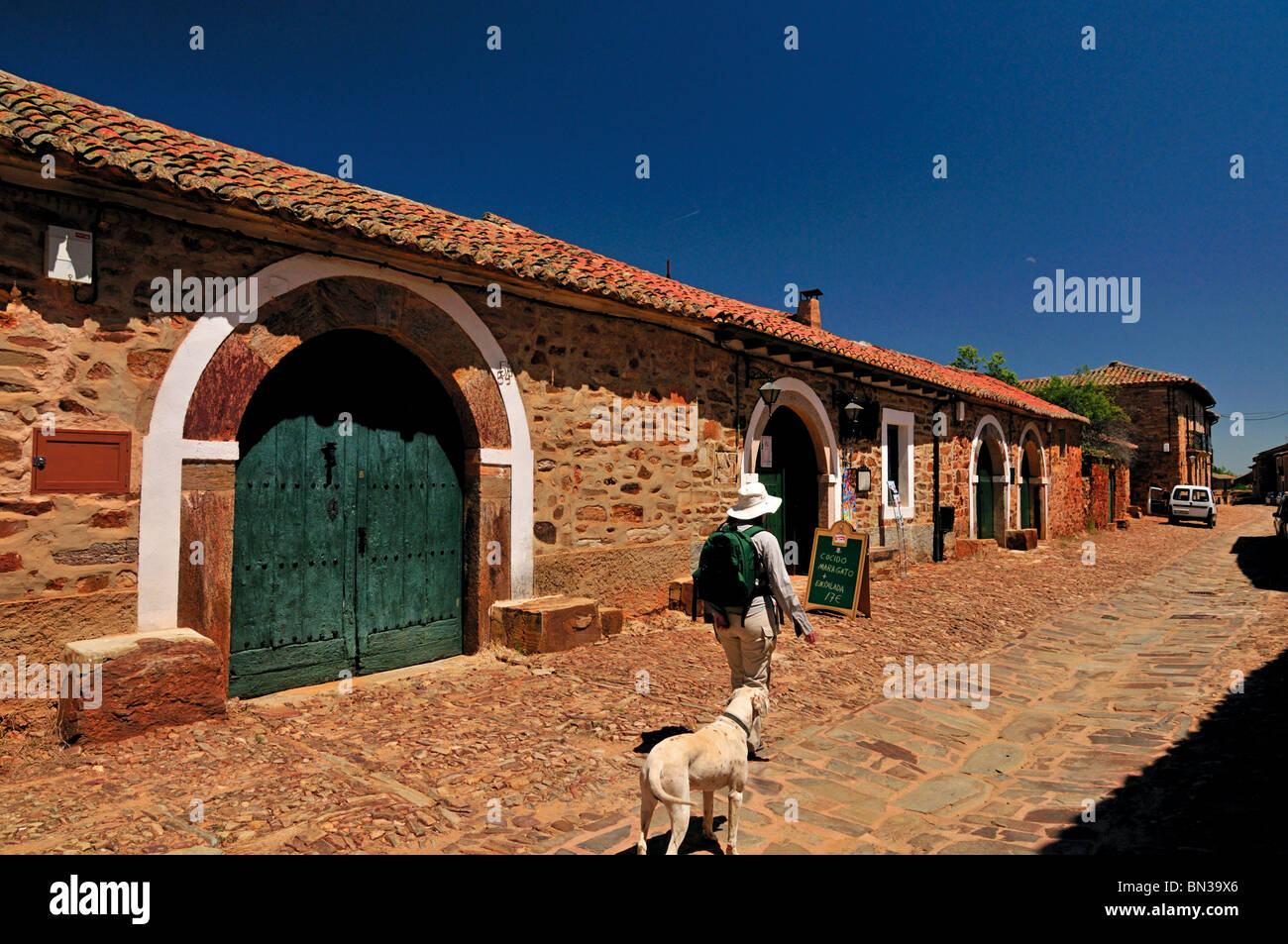 Spanien, Jakobsweg: Frau und Hund in den Straßen von Castrillo de Los Polvozares Stockfoto