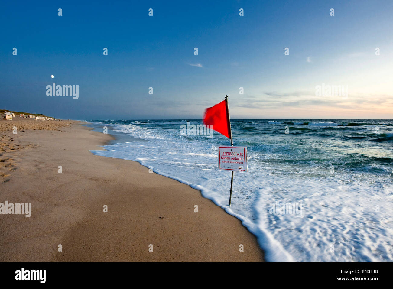 Rote Fahne und Warnschild an der Nordseeküste, Sylt, Deutschland Stockfoto