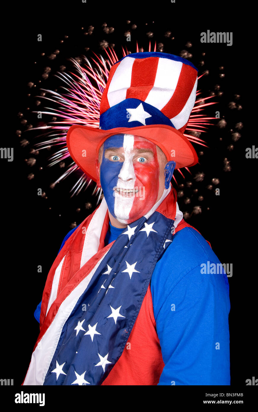 Ein patriotischer Mann gekleidet in blau, rot und weiß mit einem Feuerwerk in den schwarzen Himmel. Stockfoto