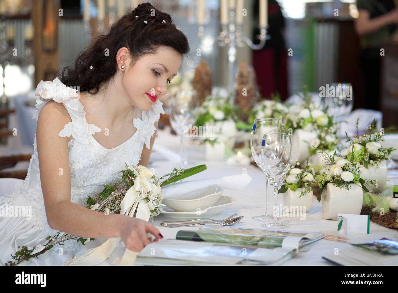 Braut sitzt an einem Tisch in einer Zeitschrift suchen Stockfoto