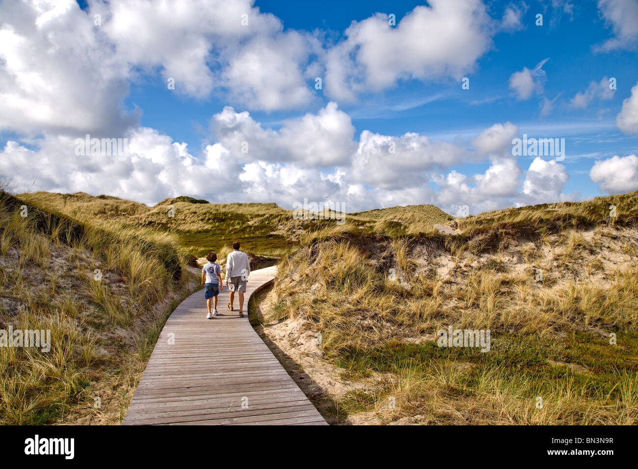 Mann und der junge Wandern auf einem Holzsteg in den Dünen, Kampen, Sylt, Deutschland Stockfoto