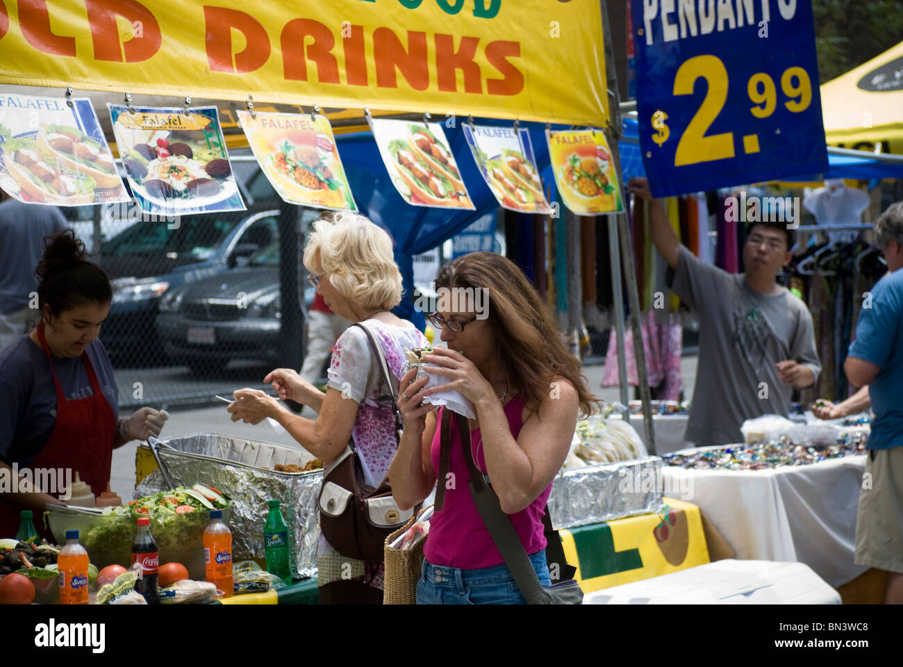 New Yorker und Besucher Essen bei einem Straßenfest auf der Sixth Avenue in New York Stockfoto