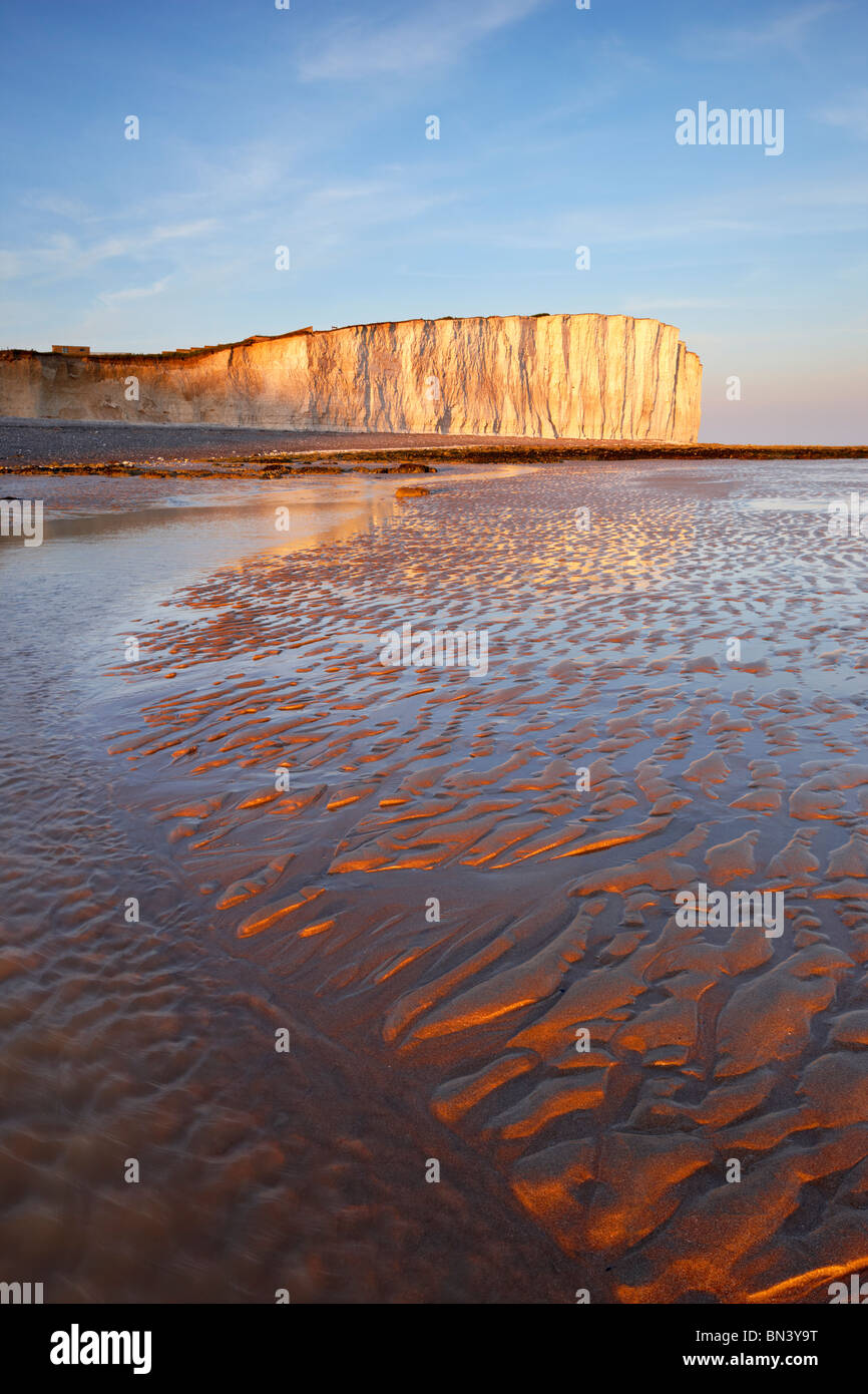 Strandblick mit Blick auf den hoch aufragenden Kreidefelsen von Beachy Head, Birling GAP durch die untergehende Sonne beleuchtet. Stockfoto