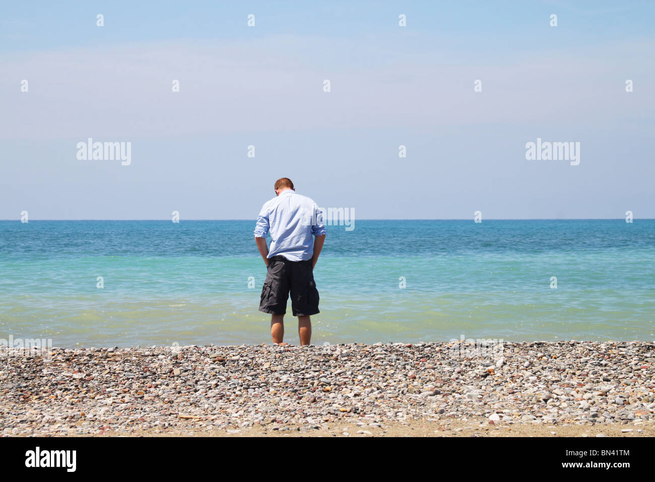 Ein Mann beobachtet die Wellen, Marina di Bibbona in der Provinz Livorno in der Toskana Stockfoto