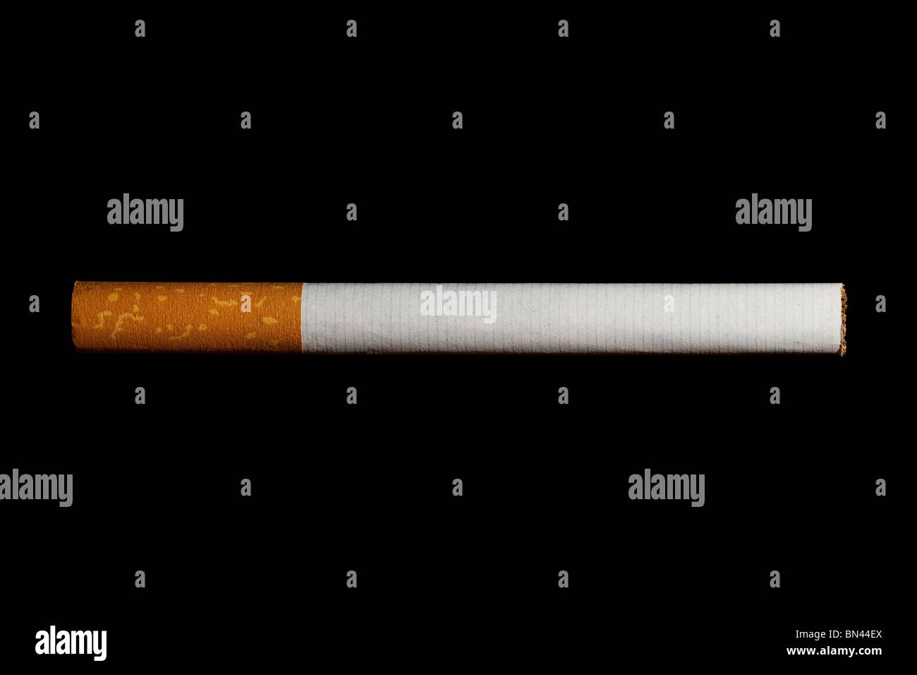 eine Zigarette mit Filter auf schwarzem Hintergrund isoliert Stockfoto