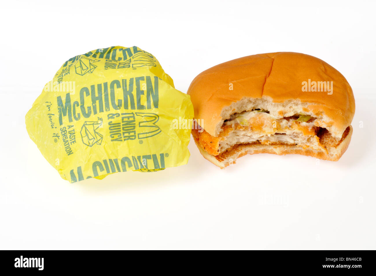 McDonald's McChicken mit einem Bissen aus ihm heraus mit Papierverpackung auf weißem Hintergrund genommen. Stockfoto