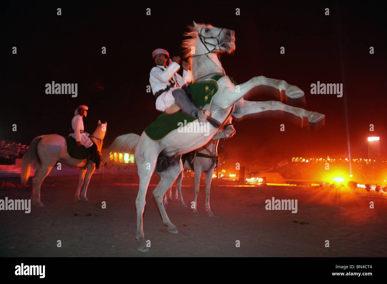 Ein Fahrer in traditionelle arabische Kleidung auf einem Aufzucht Pferd, Dubai, Vereinigte Arabische Emirate Stockfoto