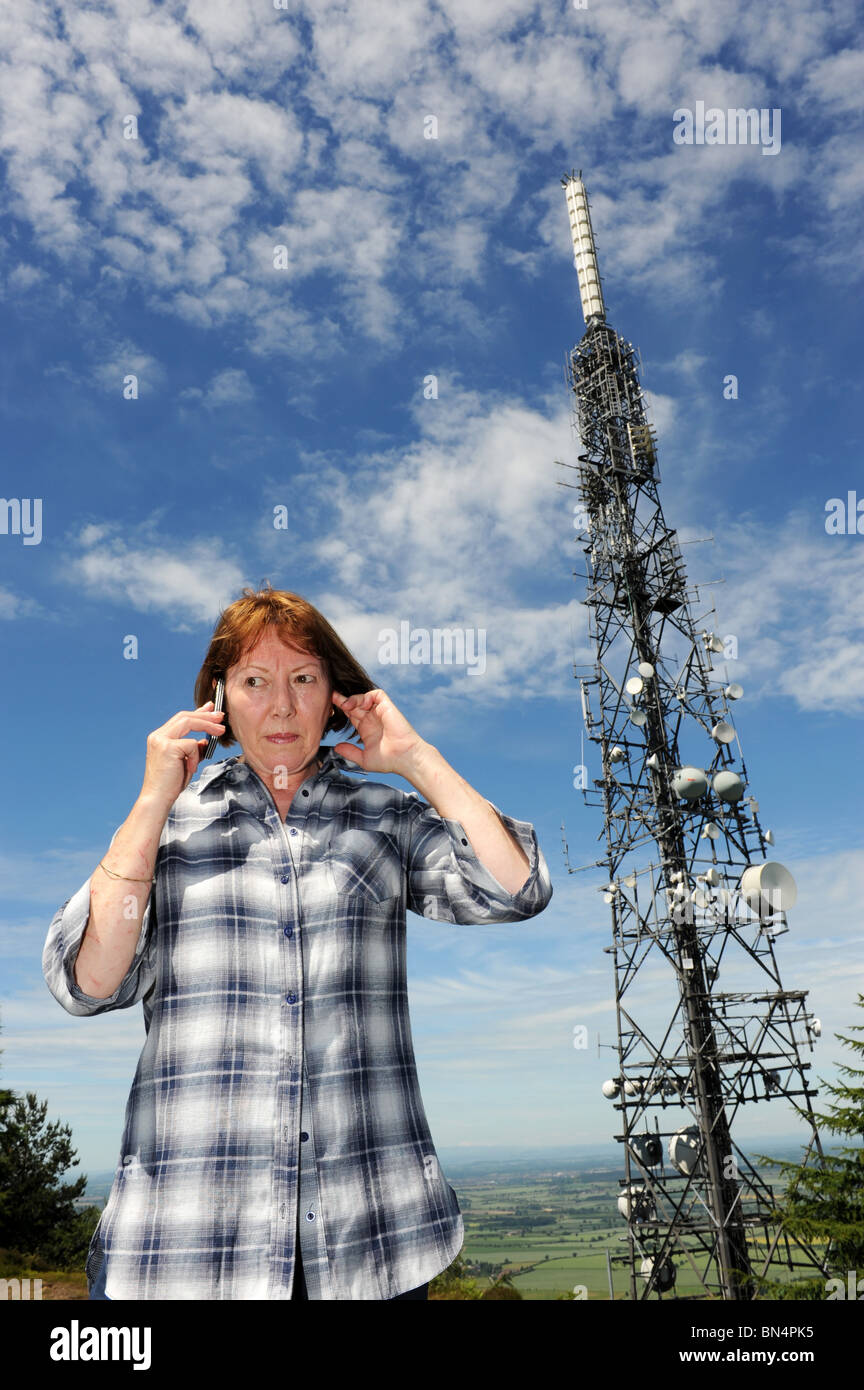 Frau mit einem Mobiltelefon neben The Wrekin Sendestation ist ein Telekommunikation und Rundfunk Sender Stockfoto